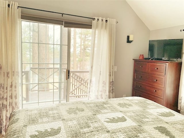 bedroom with lofted ceiling and access to outside