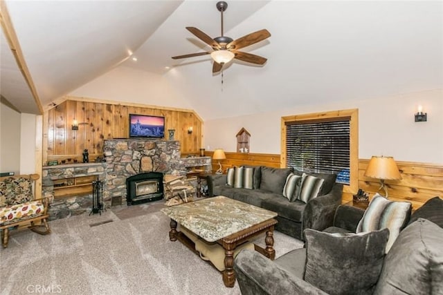 living area with a ceiling fan, carpet, wood walls, wainscoting, and vaulted ceiling