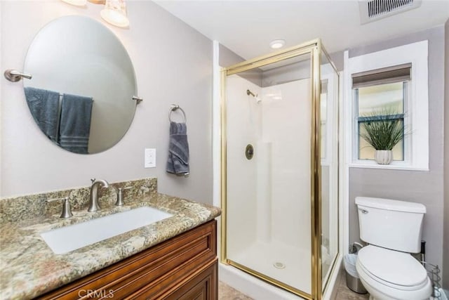 bathroom featuring visible vents, a shower stall, toilet, and vanity