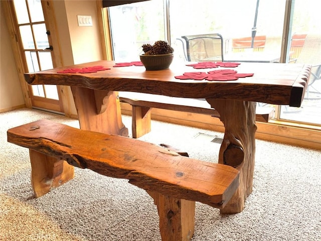 dining space featuring carpet flooring and baseboards