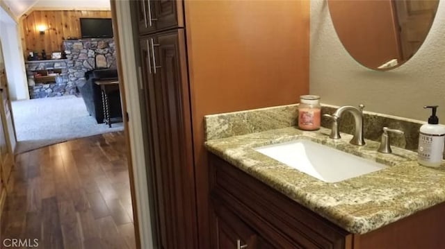 bathroom with vanity, wood finished floors, and a fireplace