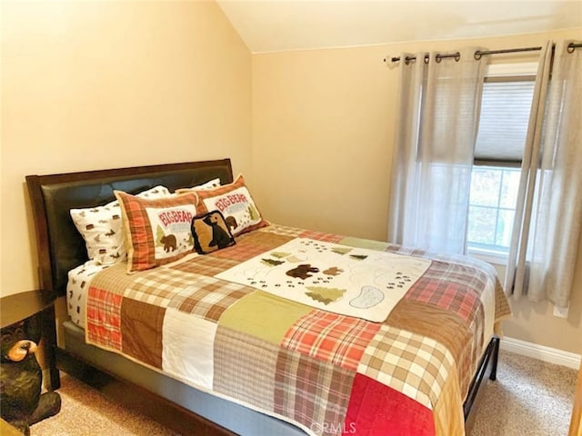 carpeted bedroom featuring baseboards and lofted ceiling