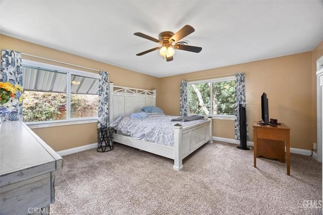 bedroom featuring light colored carpet, a ceiling fan, and baseboards