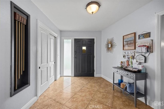 entrance foyer with light tile patterned floors and baseboards