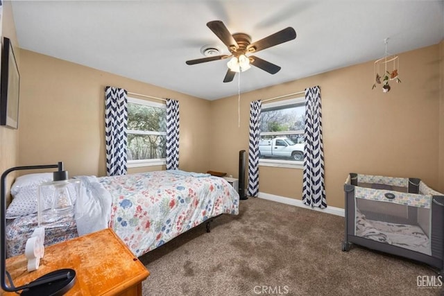 carpeted bedroom with multiple windows, baseboards, and ceiling fan