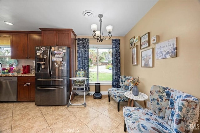 kitchen featuring tasteful backsplash, baseboards, a chandelier, appliances with stainless steel finishes, and light tile patterned flooring