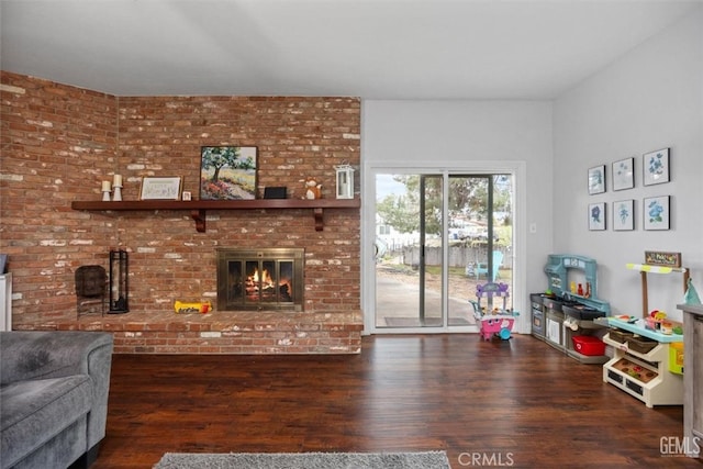 living area with a brick fireplace and wood finished floors