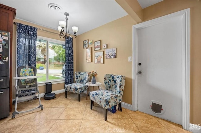 sitting room featuring light tile patterned floors, visible vents, baseboards, and an inviting chandelier