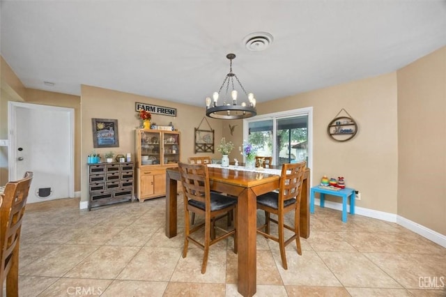 dining area featuring a chandelier, visible vents, baseboards, and light tile patterned flooring