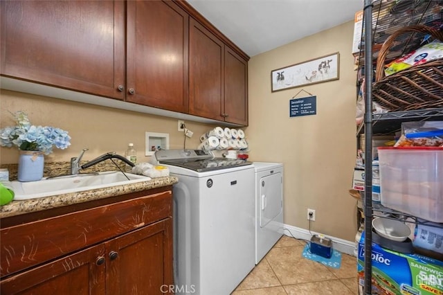 clothes washing area with baseboards, light tile patterned flooring, cabinet space, a sink, and washer and dryer