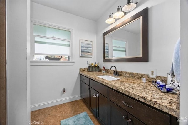 bathroom featuring tile patterned floors, baseboards, and vanity