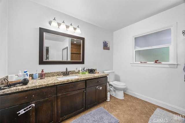 bathroom with vanity, tile patterned floors, toilet, and baseboards