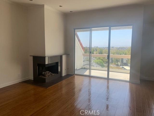 unfurnished living room featuring wood finished floors, a fireplace, and baseboards