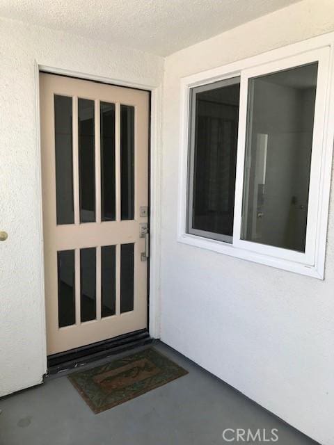 entrance to property featuring stucco siding