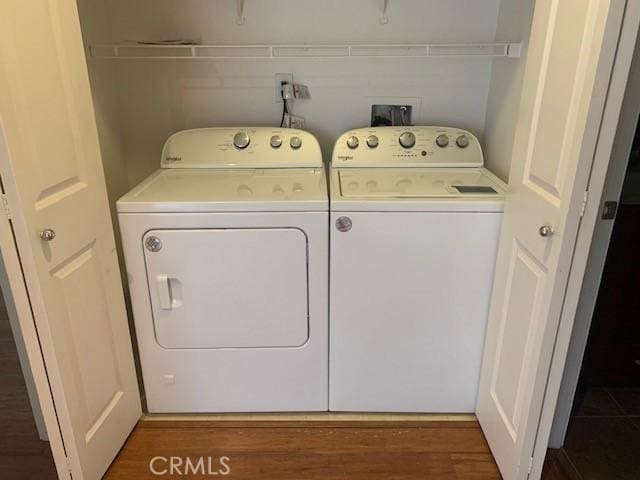 laundry area featuring laundry area, wood finished floors, and washing machine and clothes dryer