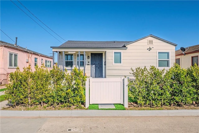 view of front of property with a fenced front yard and a gate