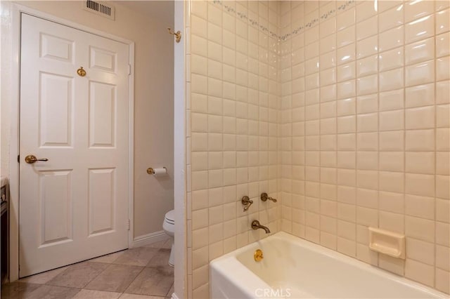 bathroom with tile patterned floors, visible vents, toilet, and a washtub