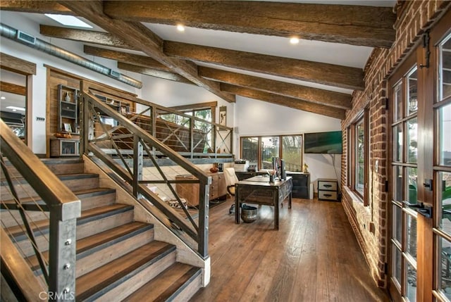 stairs with lofted ceiling with beams and hardwood / wood-style flooring