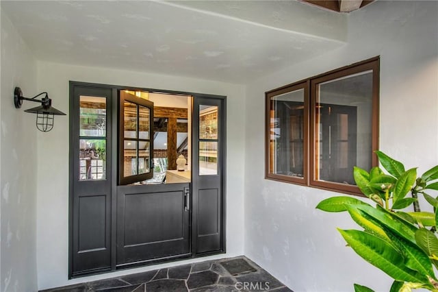 doorway to property featuring french doors and stucco siding