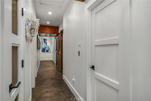 hallway with recessed lighting, baseboards, and concrete floors