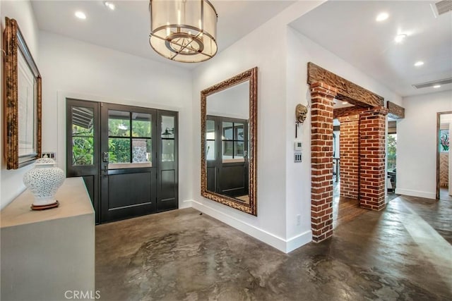 doorway to outside featuring plenty of natural light, recessed lighting, baseboards, and concrete floors