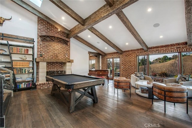 rec room with beamed ceiling, a brick fireplace, brick wall, and wood-type flooring