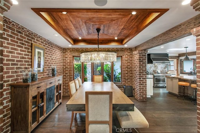 dining space featuring dark wood-style floors, a raised ceiling, wood ceiling, and brick wall