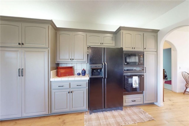 2139 Verde Canyon Rd, Arroyo Grande, CA 93420 - kitchen with black appliances, tile counters, arched walkways, backsplash, and light wood-style floors