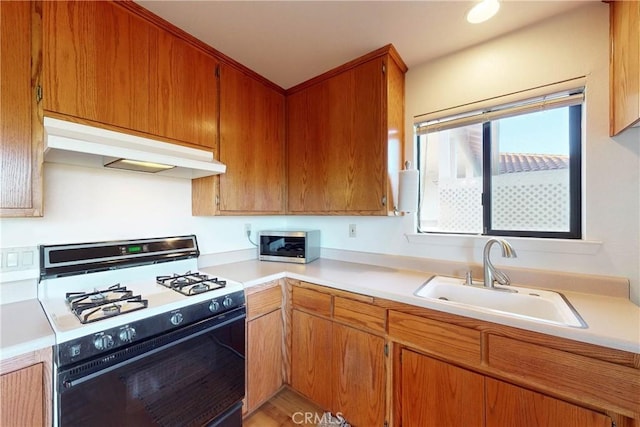 2139 Verde Canyon Rd, Arroyo Grande, CA 93420 - kitchen with range with gas stovetop, under cabinet range hood, stainless steel microwave, light countertops, and brown cabinetry