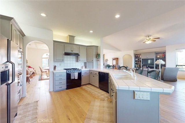 2139 Verde Canyon Rd, Arroyo Grande, CA 93420 - kitchen with range with gas stovetop, black dishwasher, gray cabinets, a peninsula, and arched walkways