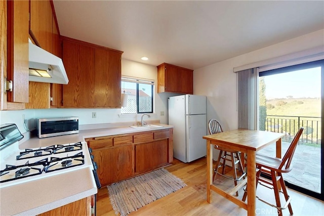 2139 Verde Canyon Rd, Arroyo Grande, CA 93420 - kitchen featuring white appliances, under cabinet range hood, light countertops, light wood-style flooring, and brown cabinetry
