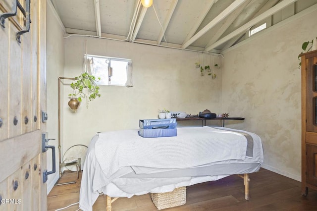 bedroom featuring lofted ceiling with beams, baseboards, and wood finished floors