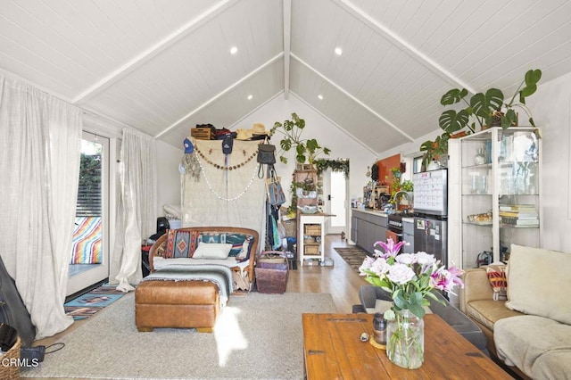 living area featuring wood finished floors and vaulted ceiling with beams