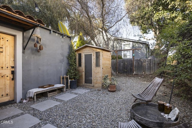 view of yard with an outdoor structure, fence, and a shed