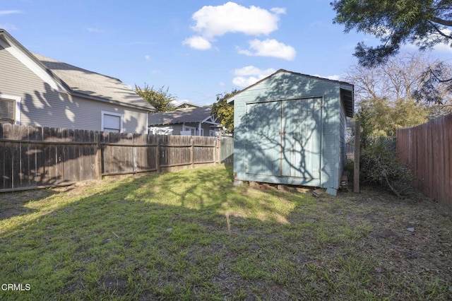 view of yard with an outbuilding, a storage unit, and a fenced backyard