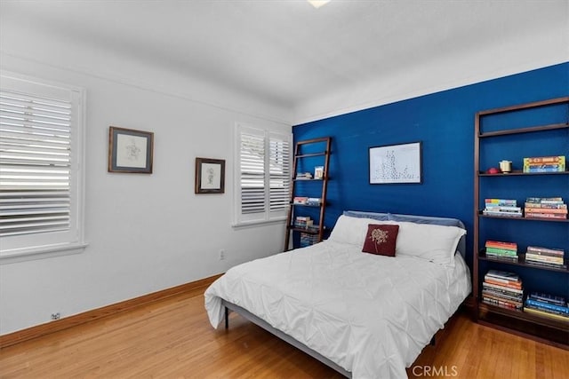 bedroom with baseboards and wood finished floors