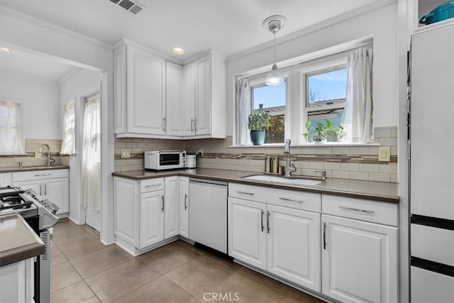 kitchen featuring dishwashing machine, visible vents, stainless steel range with gas stovetop, ornamental molding, and a sink