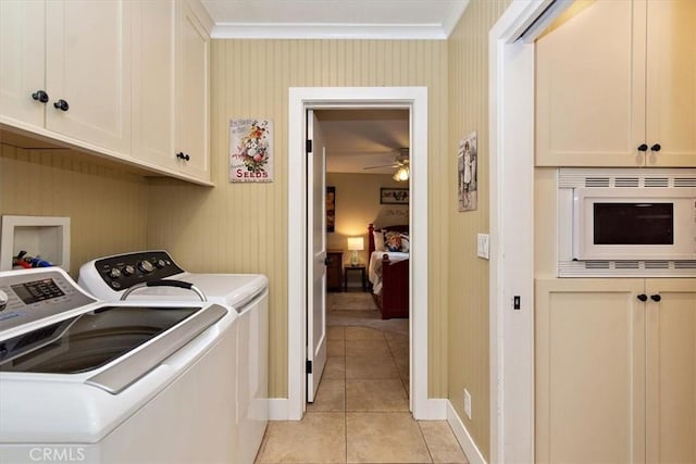 laundry room featuring washing machine and clothes dryer, ornamental molding, light tile patterned floors, cabinet space, and a ceiling fan