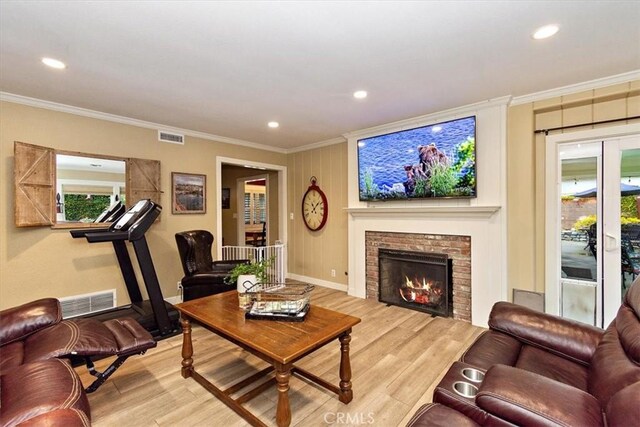 living room with visible vents, light wood-style floors, and crown molding