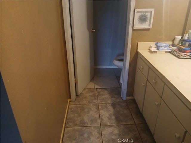 bathroom featuring tile patterned flooring, toilet, and vanity