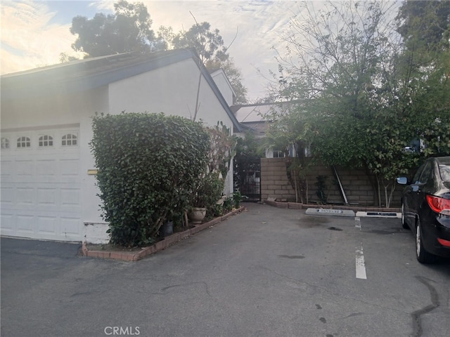 view of side of property with stucco siding and fence