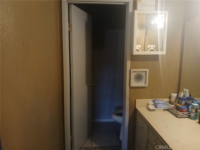 bathroom featuring tile patterned flooring, toilet, and vanity