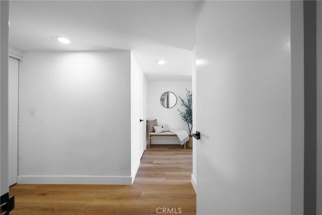 hall featuring recessed lighting, baseboards, and light wood-style flooring