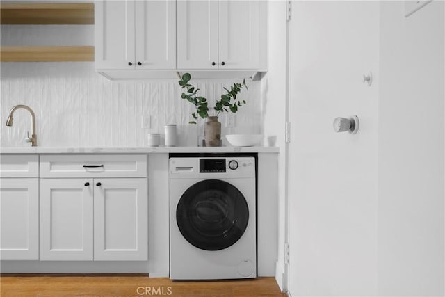 laundry area featuring washer / clothes dryer and cabinet space