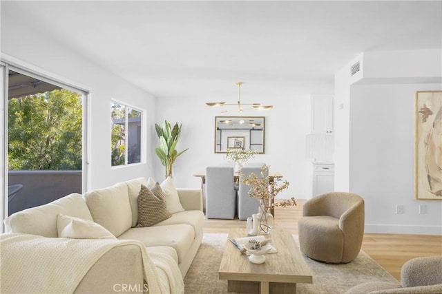 living room featuring visible vents, baseboards, and wood finished floors