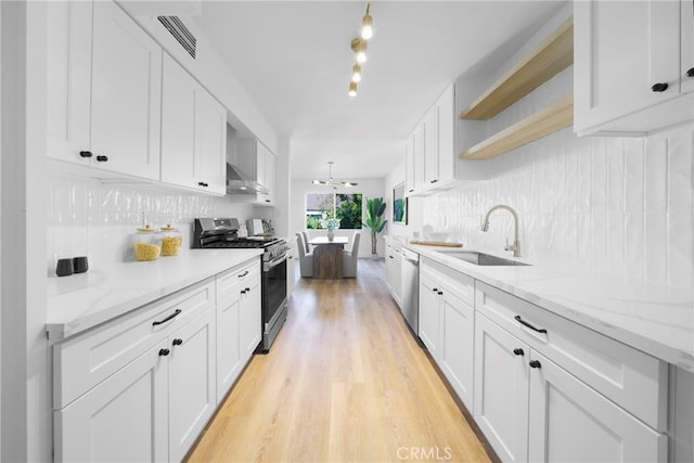 kitchen with a sink, open shelves, appliances with stainless steel finishes, wall chimney exhaust hood, and decorative backsplash