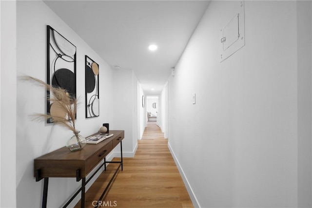 corridor featuring recessed lighting, baseboards, and light wood-style floors