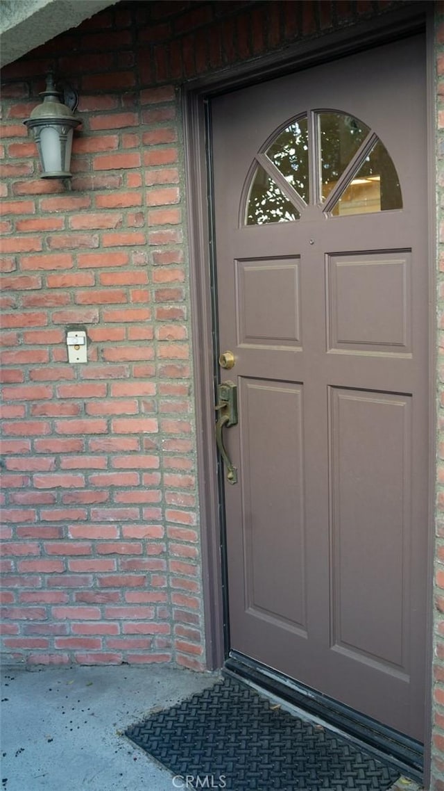 view of exterior entry featuring brick siding