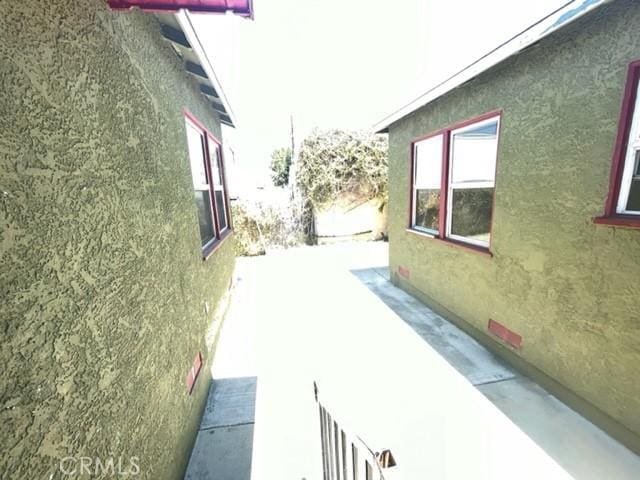 view of side of property with a patio area and stucco siding