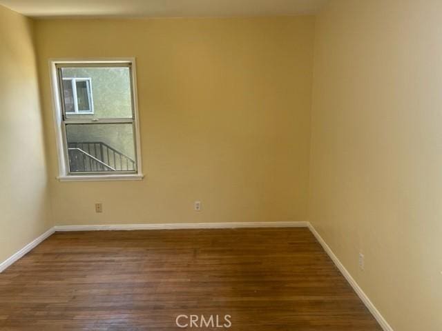 empty room featuring baseboards and wood finished floors